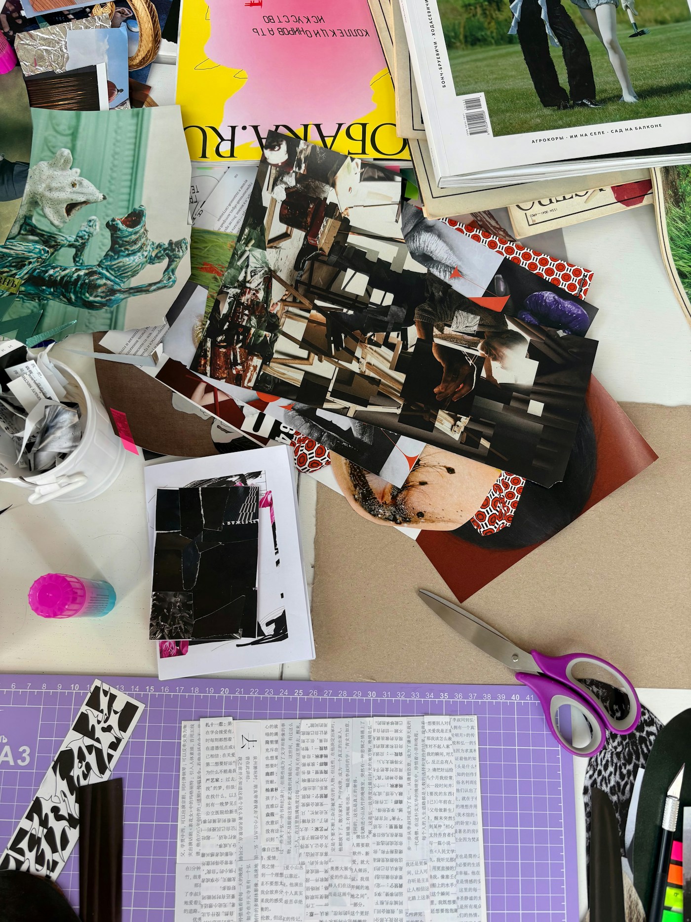 Ausgeschnittene Magazinbilder, Papier und Schere auf einer bunten Collage-Arbeitsfläche
